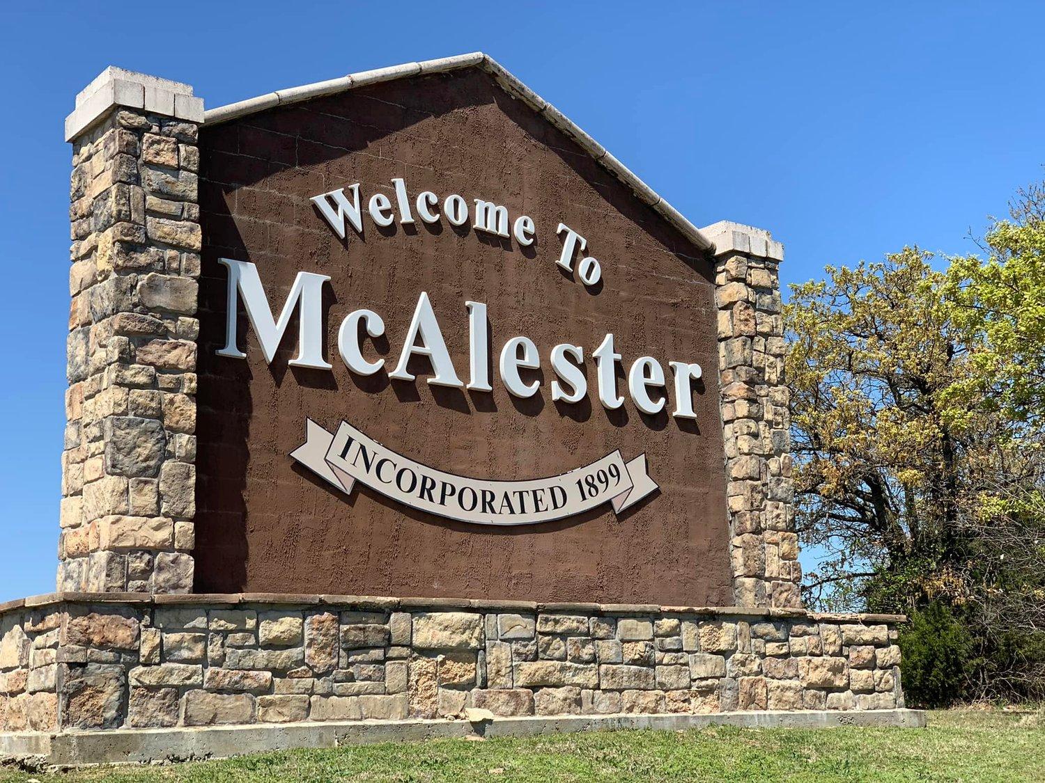 Stone and brick welcome sign reading Welcome to McAlester, Incorporated 1899, under a clear blue sky