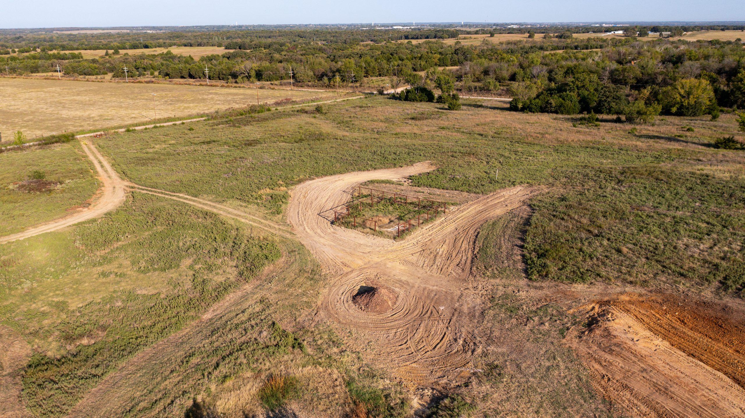 Aerial view of newly cut dirt roads and a turnaround carved into cleared rural acreage in Lincoln County, Oklahoma
